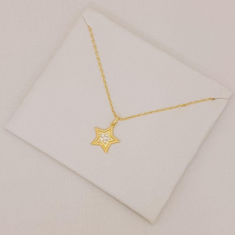 09.2591.1.O - (45) Colar em cartier com pingente de estrela com central cravejada e borda larga em efeito spikes
