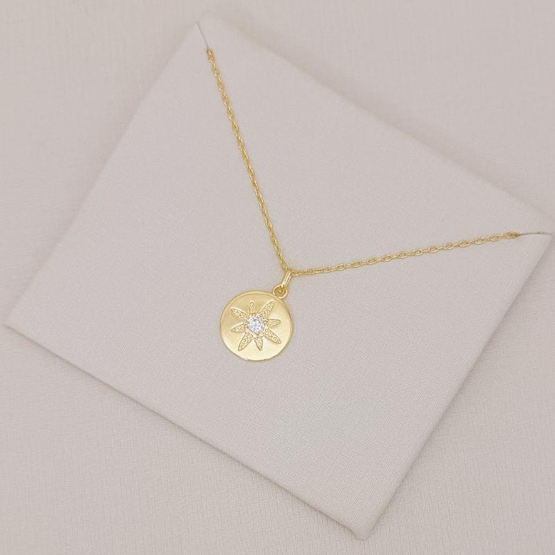 09.2593.1.O - (45) Colar de elo cartier com pingente de rosa dos ventos em moeda com central em ponto de luz