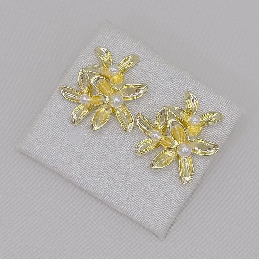 06.1427.15.B - Brinco de três flores de quatro pétalas lisas com pérolas centrais. Brinco banhado a ródio.