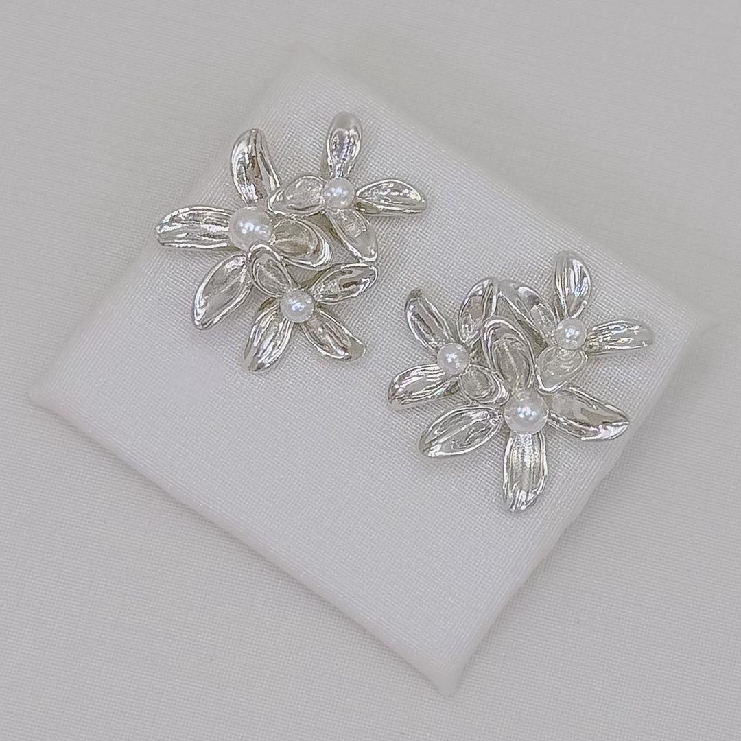 06.1427.15.O - Brinco de três flores de quatro pétalas lisas com pérolas centrais. Brinco banhado a ouro.