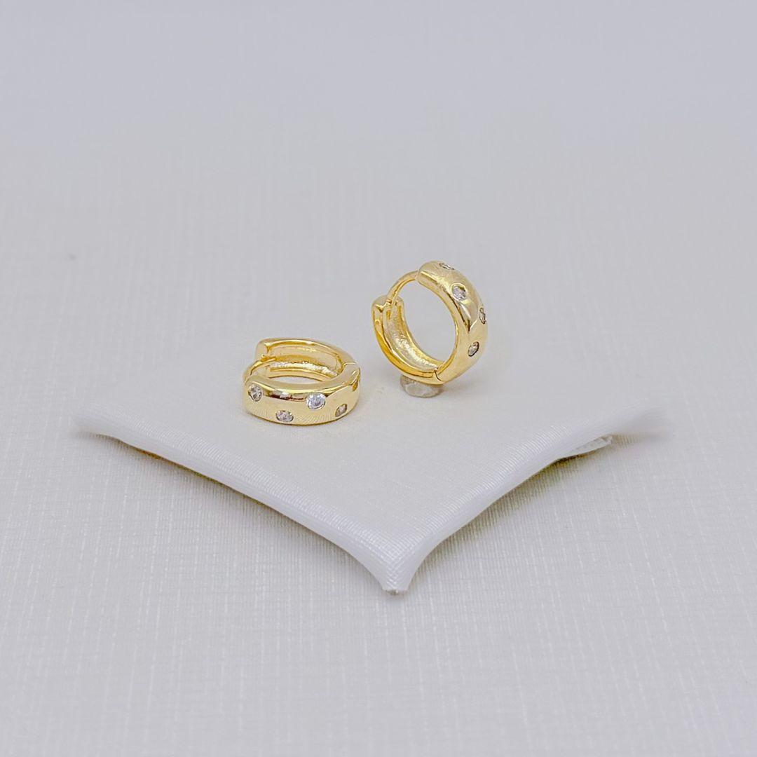 05.3340.1.O - Argola de fio simples com zircônias em efeito cosmos gypsy. Argola banhada a ouro.