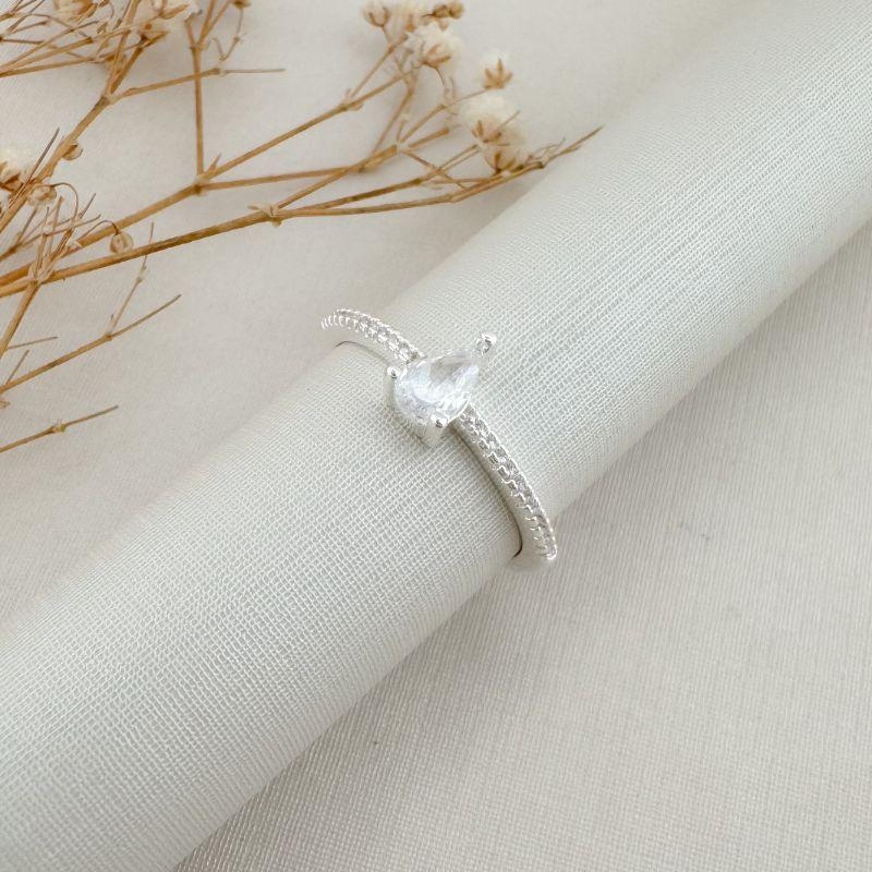 03.2447.1.S - (19) Anel solitário de gota com aro cravejado