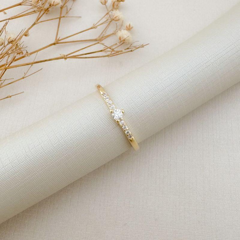 03.2431.1.O - (21) Anel solitário em três garras com cravação nas laterais do aro