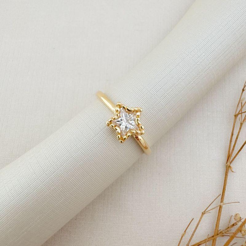 03.2438.1.O - (18) Anel de pedra em formato estrela com borda em spikes e aro liso