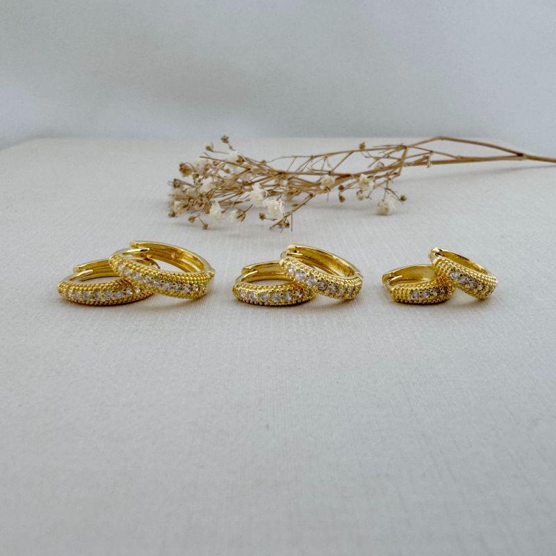 05.2736.1.O - Trio de argola formato garra com uma colina cravejada central