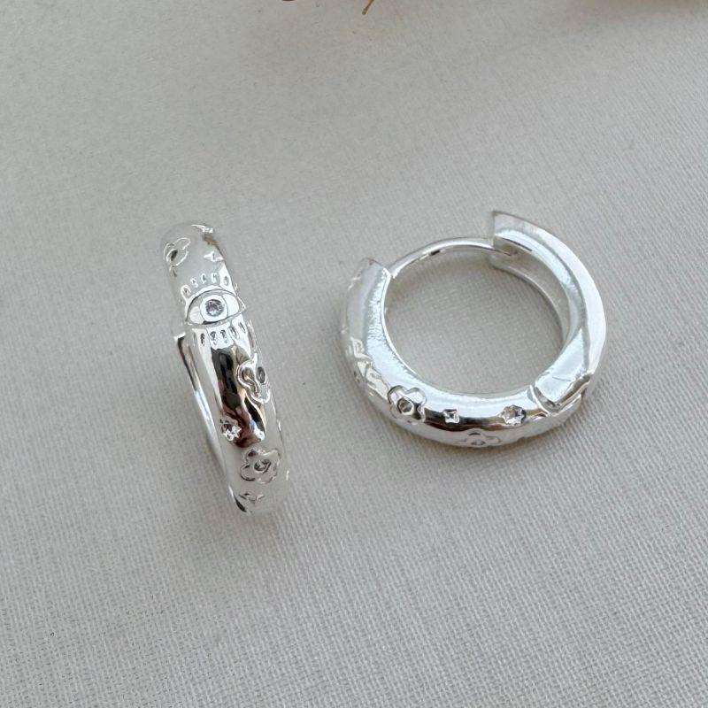 05.2908.1.S - Argola circular de tubo oval com desenhos de flores e olho com micro zirconias espalhadas