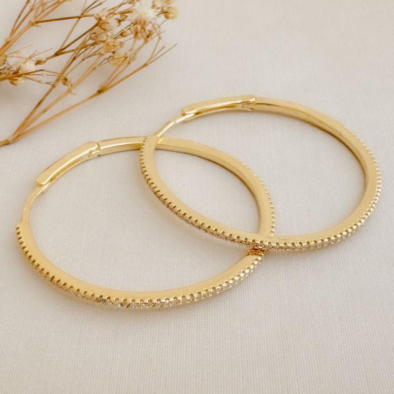 05.3054.1.O - Argola máxi de 40mm de diâmetro com parte frontal cravejada em uma coluna