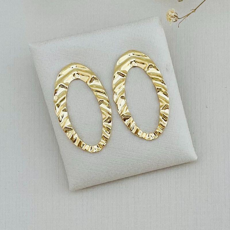 06.1800.0.O - Brinco em chapa de formato oval em efeito orgânico com centro vazado