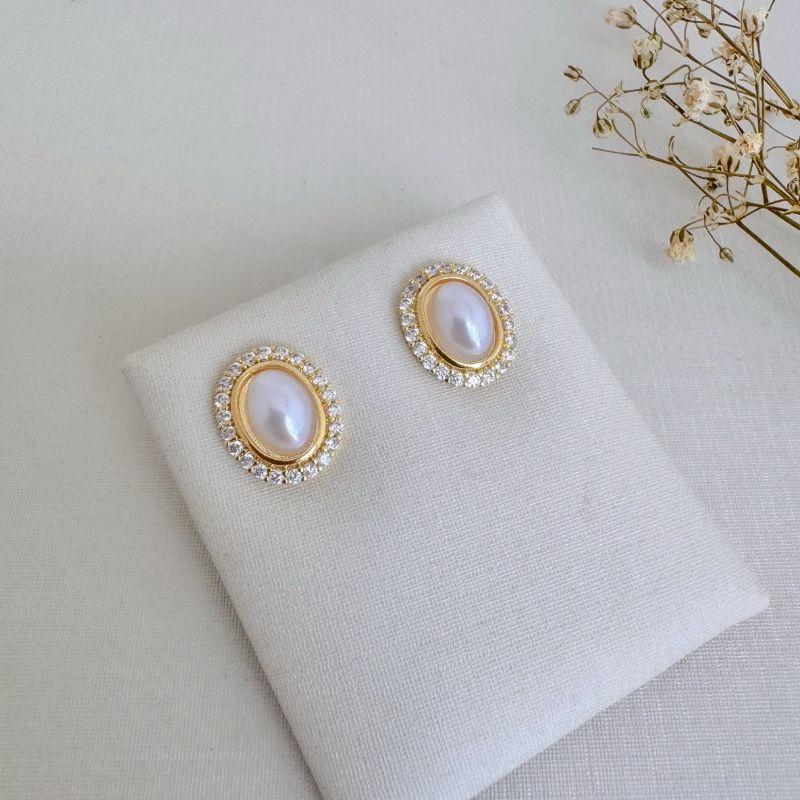 07.2714.15.O - (Tam.G) Brinco oval com pérola central e uma coluna de cravação em volta