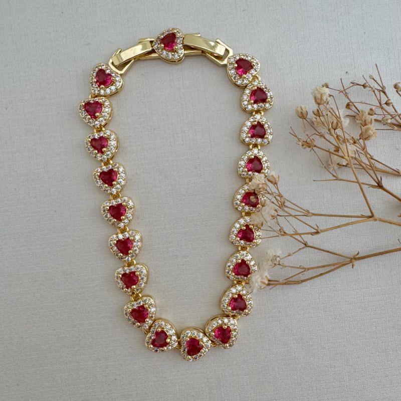 12.2172.6.O - Pulseira de corações rivera, pedra grande central e uma coluna de cravação. Possui extensor.