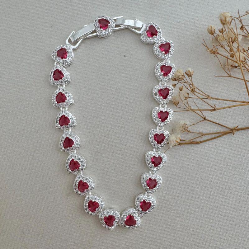 12.2172.6.S - Pulseira de corações rivera, pedra grande central e uma coluna de cravação. Possui extensor.