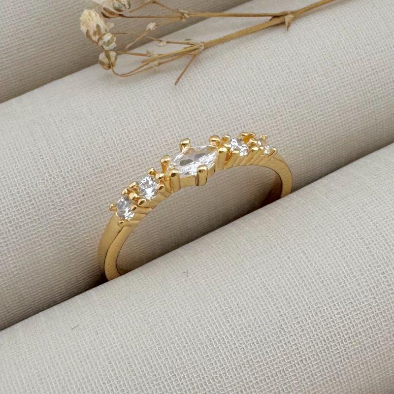 03.2326.1.O - (18) Anel com pedra central em navete e pontos de luz cravejados no aro