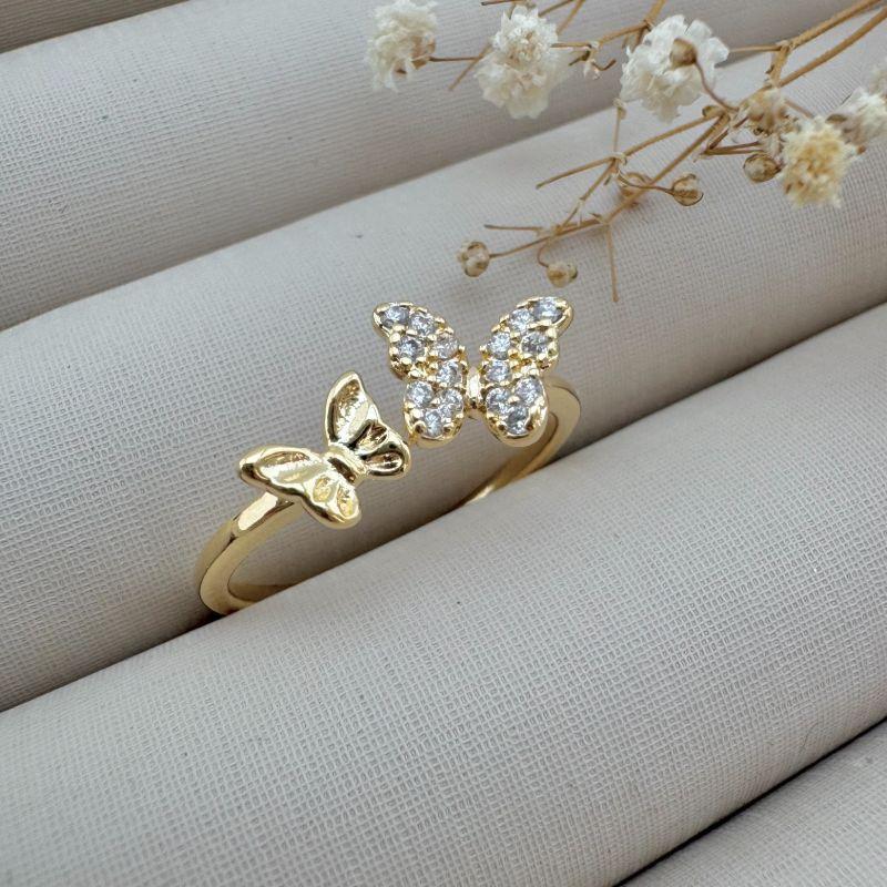 03.2346.1.O - (14 a 17) Anel de aro fino liso aberto com uma borboleta lisa e uma cravejada