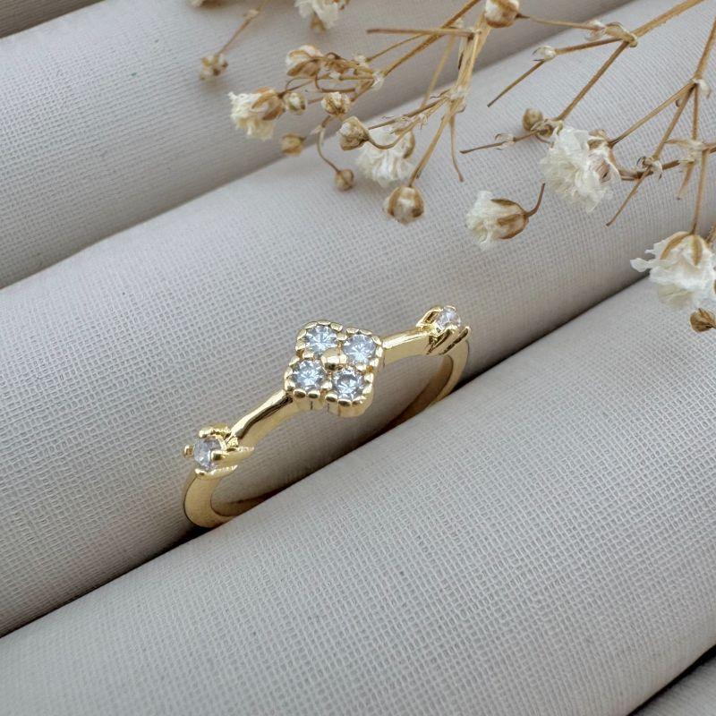 03.2347.1.O - (18) Anel de aro fino com flor de alhambra central e um ponto de luz em cada lateral