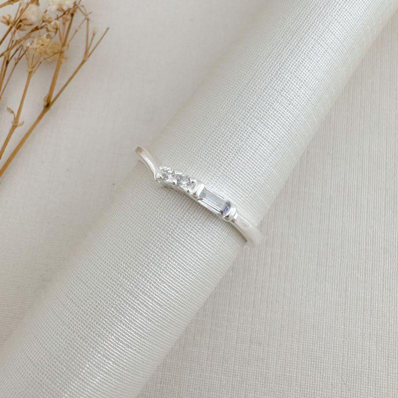 03.2474.1.S - (19) Anel de aro liso com central de pedra baguete seguida de duas zircônias