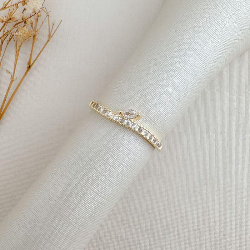 03.2479.1.O - (19) Anel de aro ondulado de uma linha cravejada com uma pedra navete