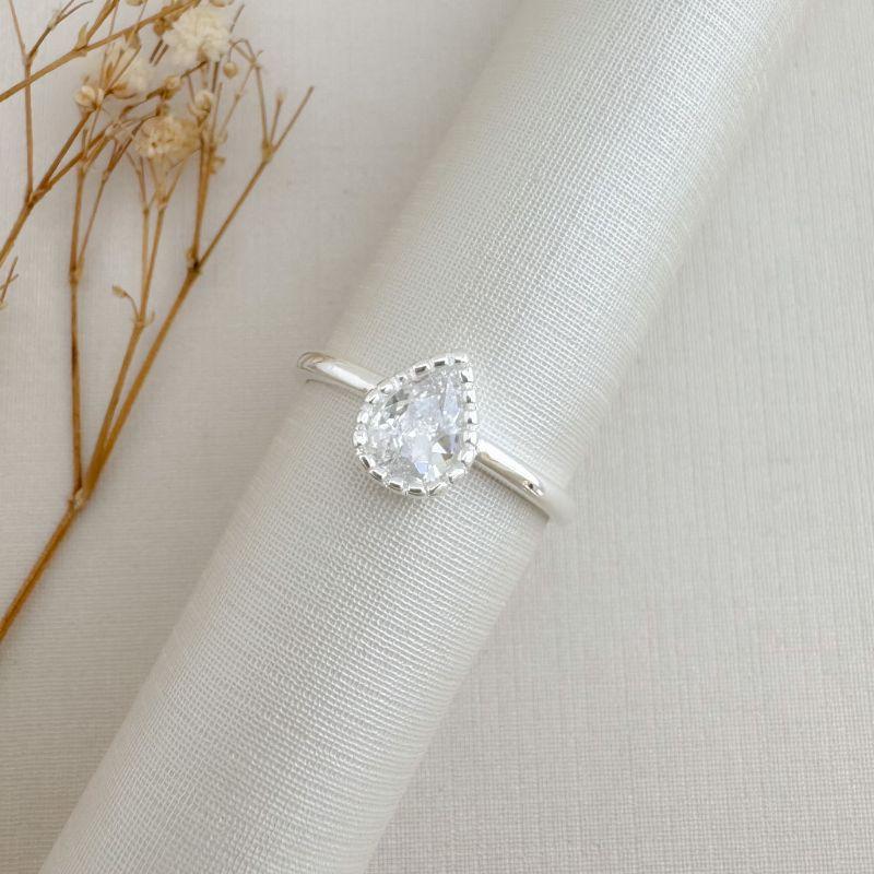 03.2488.1.S - (22) Anel solitário de gota em cravação barras em aro liso