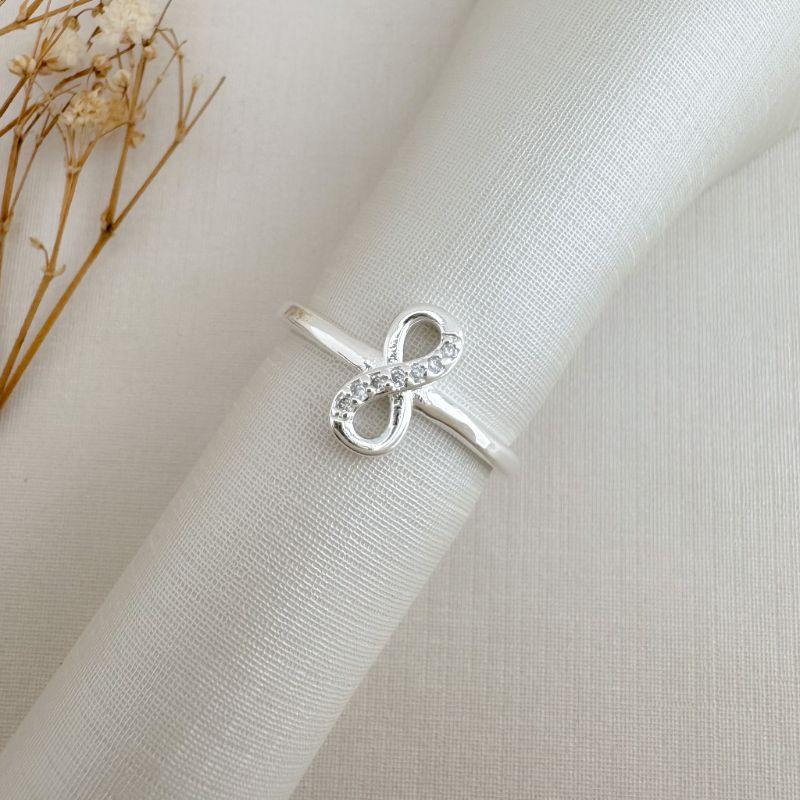 03.2494.1.S - (17) Anel de infinito vertical com um lado cravejado em aro liso