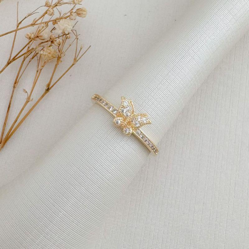 03.2495.1.O - (16) Anel de borboleta desenhada e cravejada em aro estilo aparador cravejado