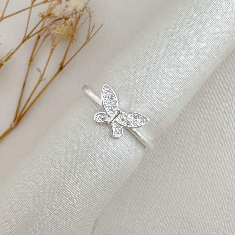 03.2500.1.S - (17) Anel de borboleta em navete cravejada em aro liso