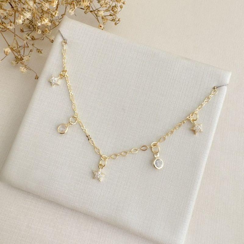 09.2368.1.O - (32) Colar choker com pingentes de estrela cravejada e pontos de luz, corrente de elo americano