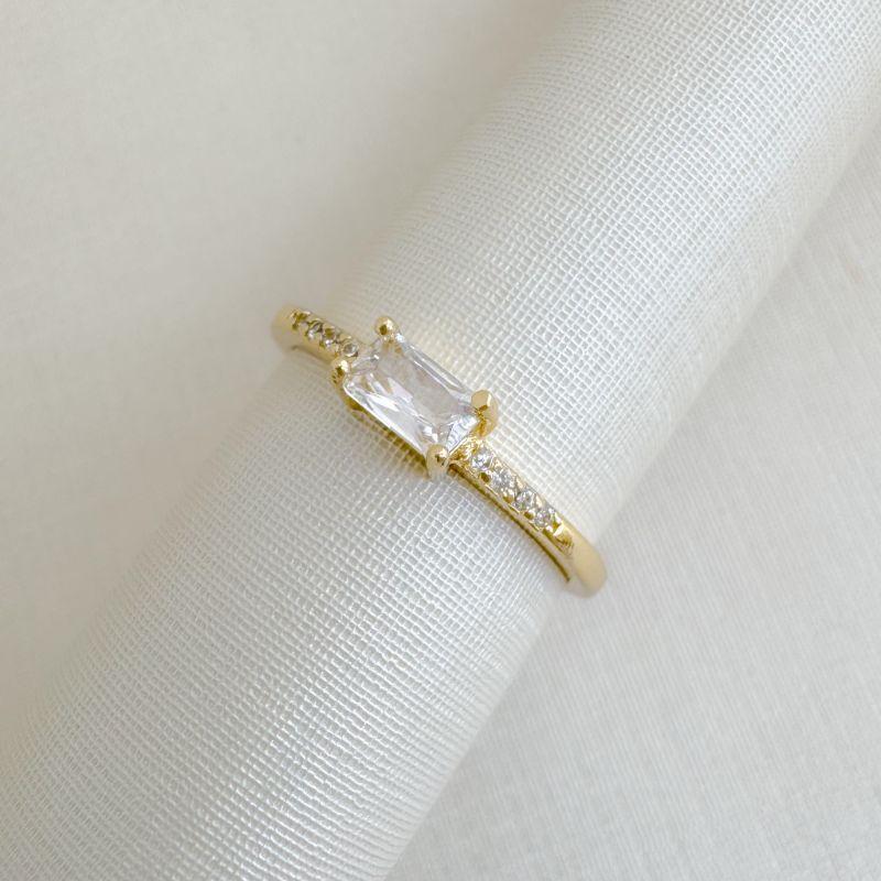 03.2516.1.O - (14) Anel solitário de pedra baguete com aro cravejado nas laterais