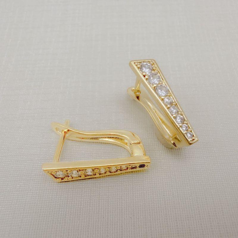 05.3095.1.O - Argola frente reta cravejada com detalhe em cima pontudo, parte de cima mais larga e parte debaixo mais estreita.