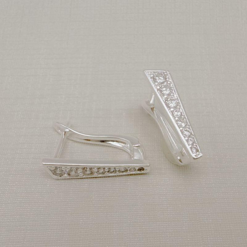 05.3095.1.S - Argola frente reta cravejada com detalhe em cima pontudo, parte de cima mais larga e parte debaixo mais estreita.