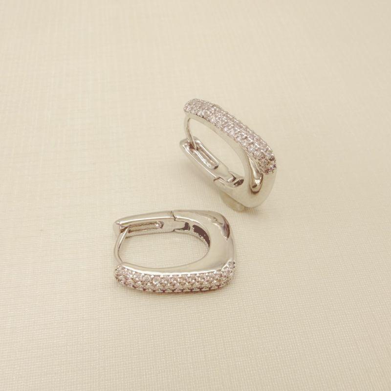 05.3107.1.B - Argola em formato retangular abaloado com três colunas de zircônias na frente.