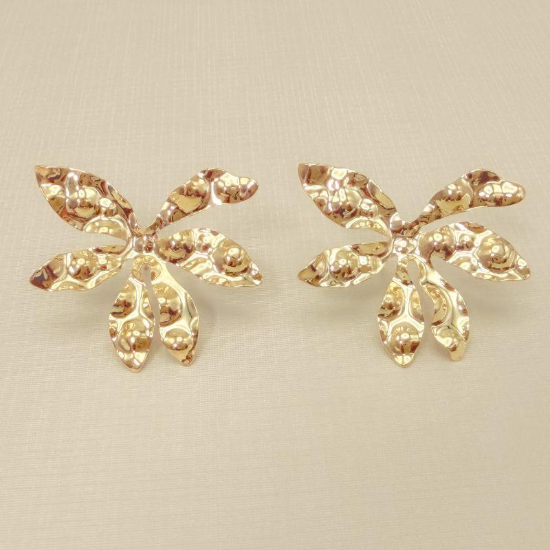 06.1324.0.O - Brinco folha de bordo com chapa trabalhada com amassados circulares.