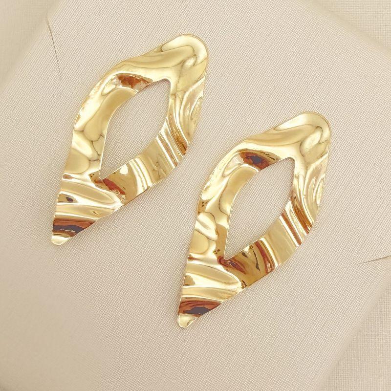 06.1326.0.O - Brinco formato navete com desenho vazado no centro em formato navete e detalhes amassados na chapa, brinco orgânico.