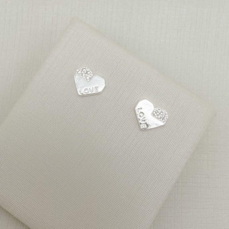 07.2773.1.S - Brinco coração lapidado, com detalhes cravejados e escrito LOVE.