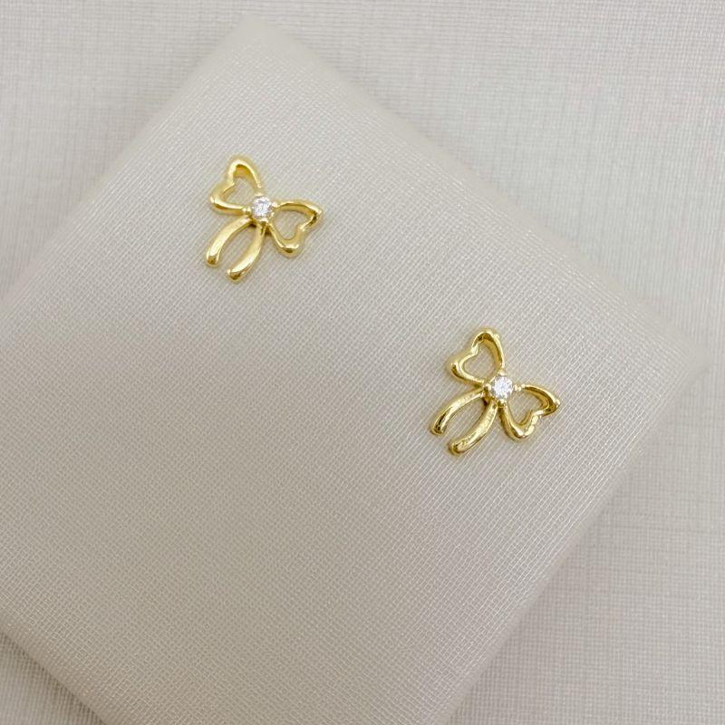 07.2814.1.O - Brinco silhueta lacinho com ponto de luz no centro.