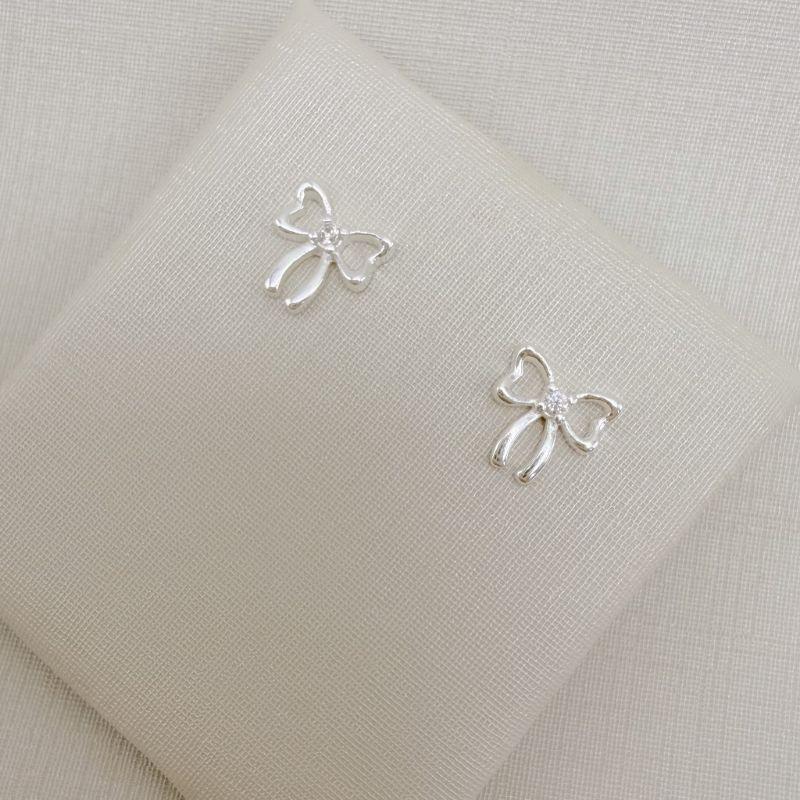 07.2814.1.S - Brinco silhueta lacinho com ponto de luz no centro.