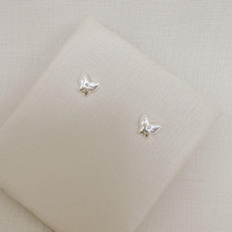 07.2818.1.S - Brinco de borboleta lisa com uma zircônia no centro, média de três.