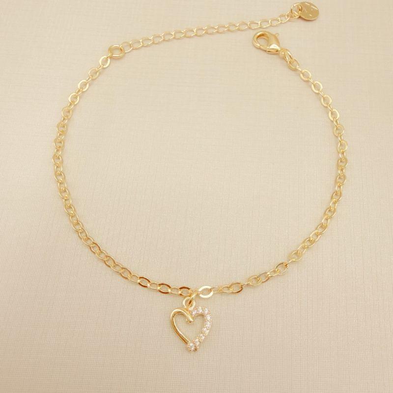 12.2271.1.O - Pulseira pingente de silhueta de coração com uma lateral cravejada, elo americano 2,4mm de espessura.