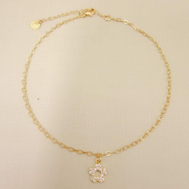 14.0335.1.O - Tornozeleira com pingente de flor cravejada e círculo vazado no centro, malha elo oval e elo infinito.