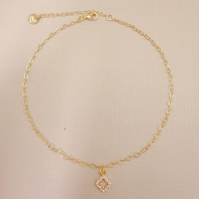 14.0336.1.O - Tornozeleira com pingente de silhueta de flor alhambra cravejada, insp. Van-Cleef, malha elo oval e elo infinito.