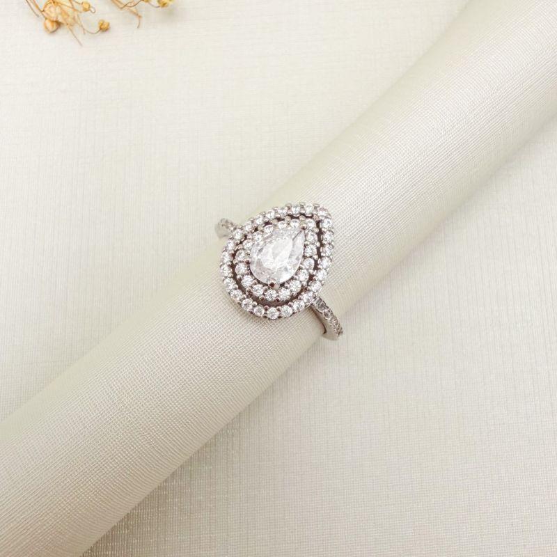 03.2545.1.B - (17) Anel solitário em gota com duas linhas de aura espaçadas com galeria em aro metade cravejado