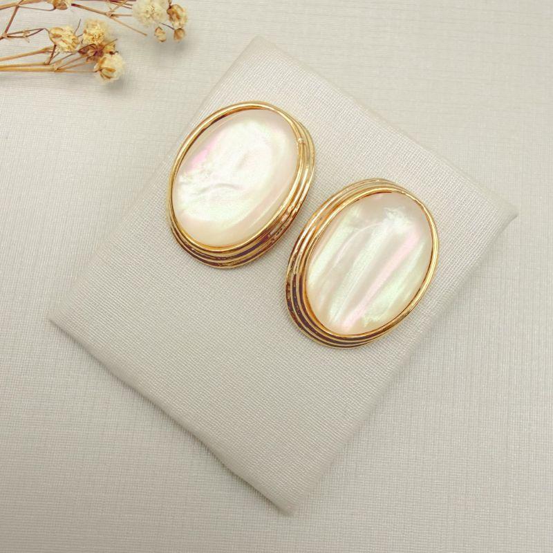 06.1349.15.O - Brinco oval em madre pérola com borda larga em efeito escada lisa