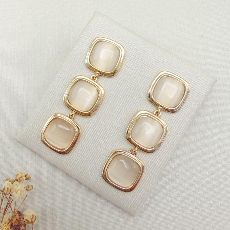 06.1354.15.O - Brinco comprido de três quadrados em madre com borda larga isa