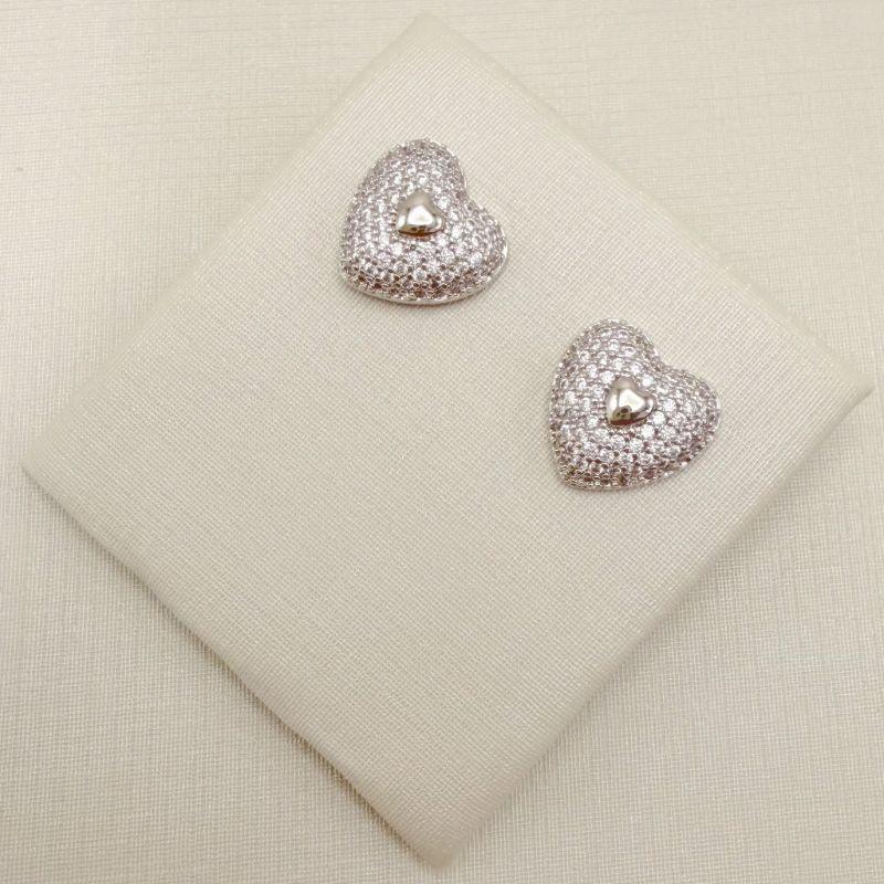 07.2848.1.B - Brinco de formato coração cravejado com central em mini coração liso