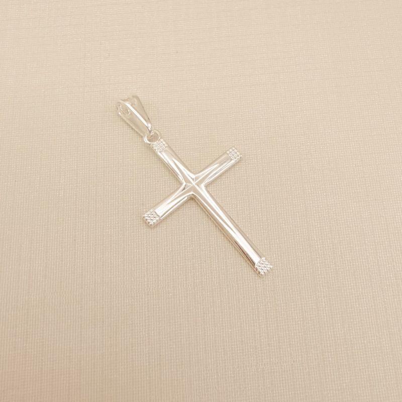 11.0612.0.S - Pingente cruz 23x16mm com pontas/extremidades pontilhadas e detalhe em baixo relevo diamantado no centro.