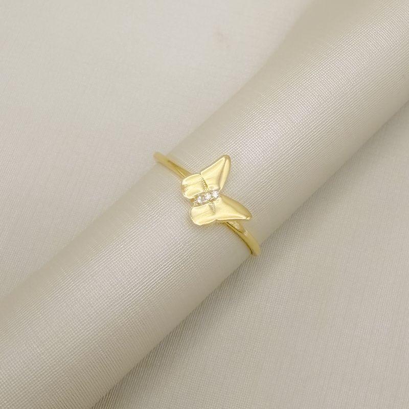 03.2568.1.O - (23) Anel de aro liso fino com central de borboleta lisa e traço cravejado