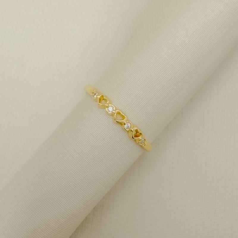 03.2597.1.O - (21) Anel de aro liso com três silhuetas de coração e pontos de luz intercalados