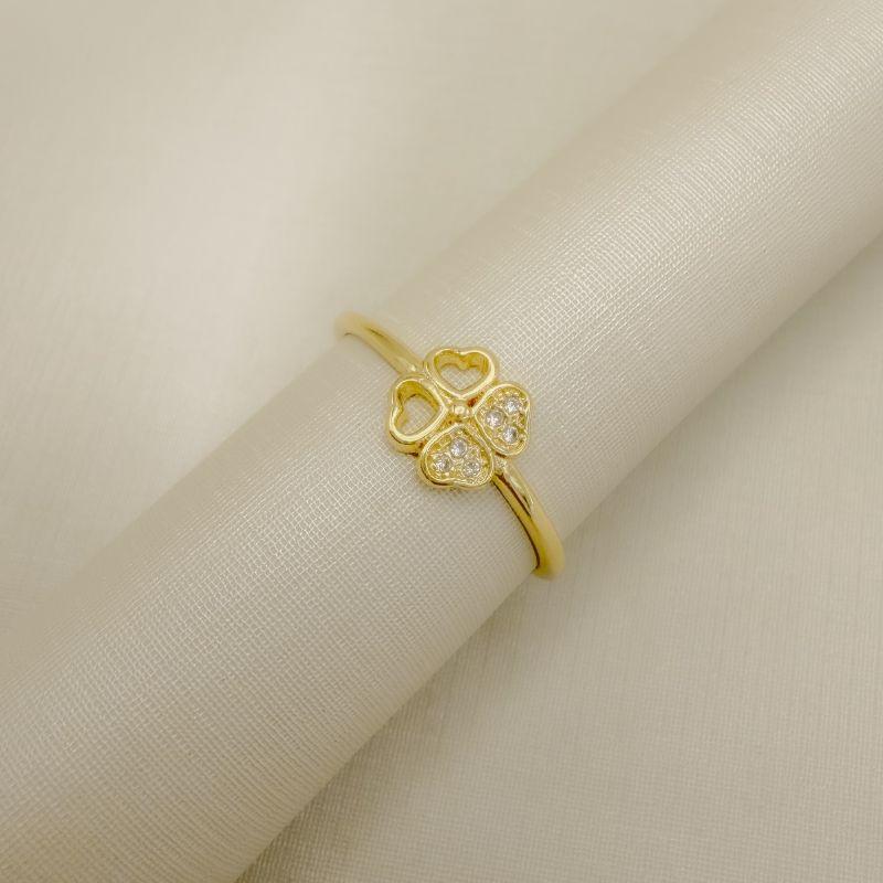 03.2607.1.O - (23) Anel de aro fino com trevo quatro folha central de dois lados lisos e dois lados cravejados