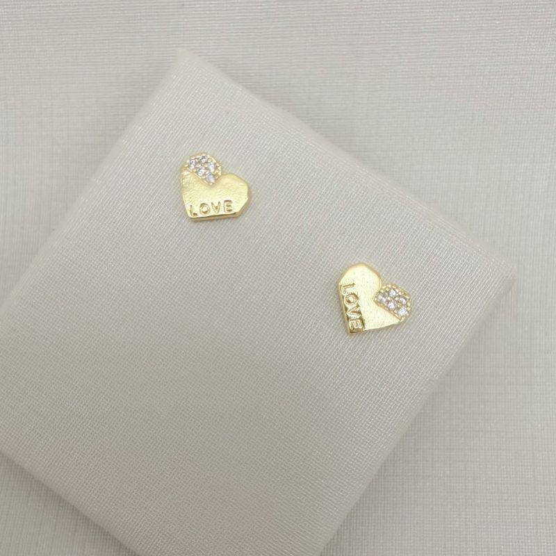 07.2773.1.O - Brinco coração lapidado, com detalhes cravejados e escrito LOVE.