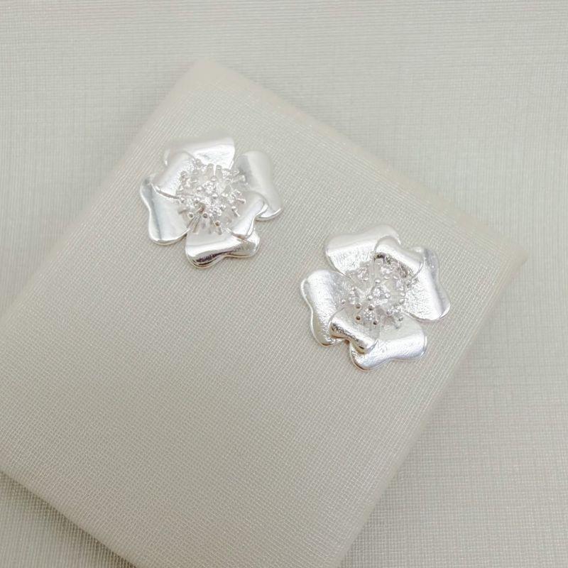 07.2775.1.S - Brinco flor quatro pétalas grandes e duas pétalas pequenas, centro em zircônias em alto relevo.