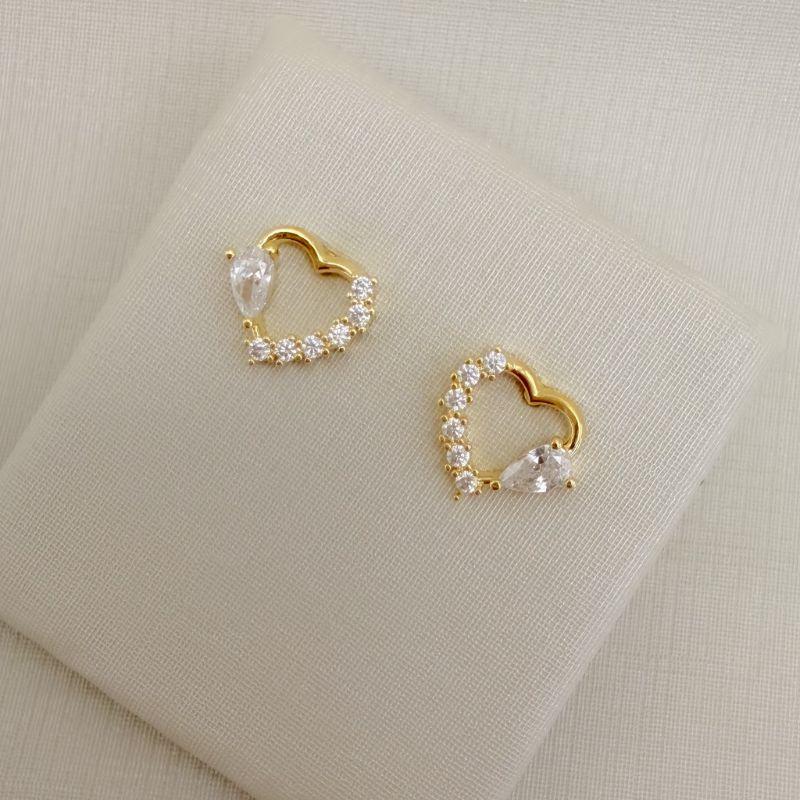 07.2792.1.O - Brinco silhueta de coração com metade cravejada e metade com uma zircônia em gota.