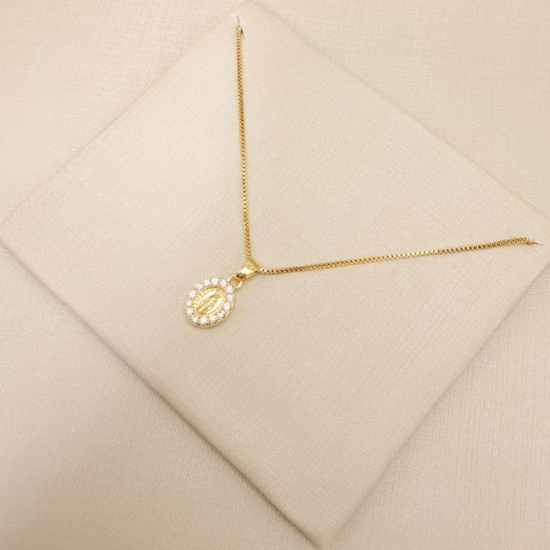 09.2438.1.O - (45) Colar pingente oval com Nossa Senhora das Graças no centro e borda cravejada e verso o Monograma Mariano.